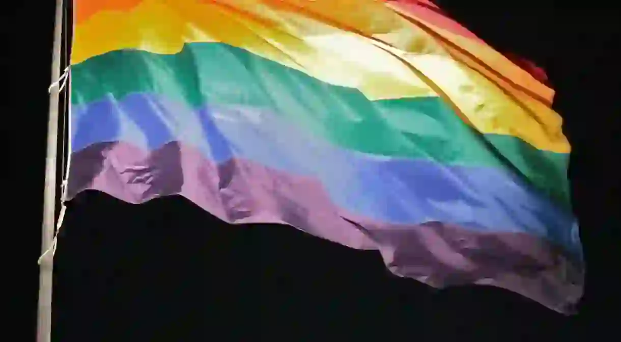 A rainbow Pride flag set against a night sky