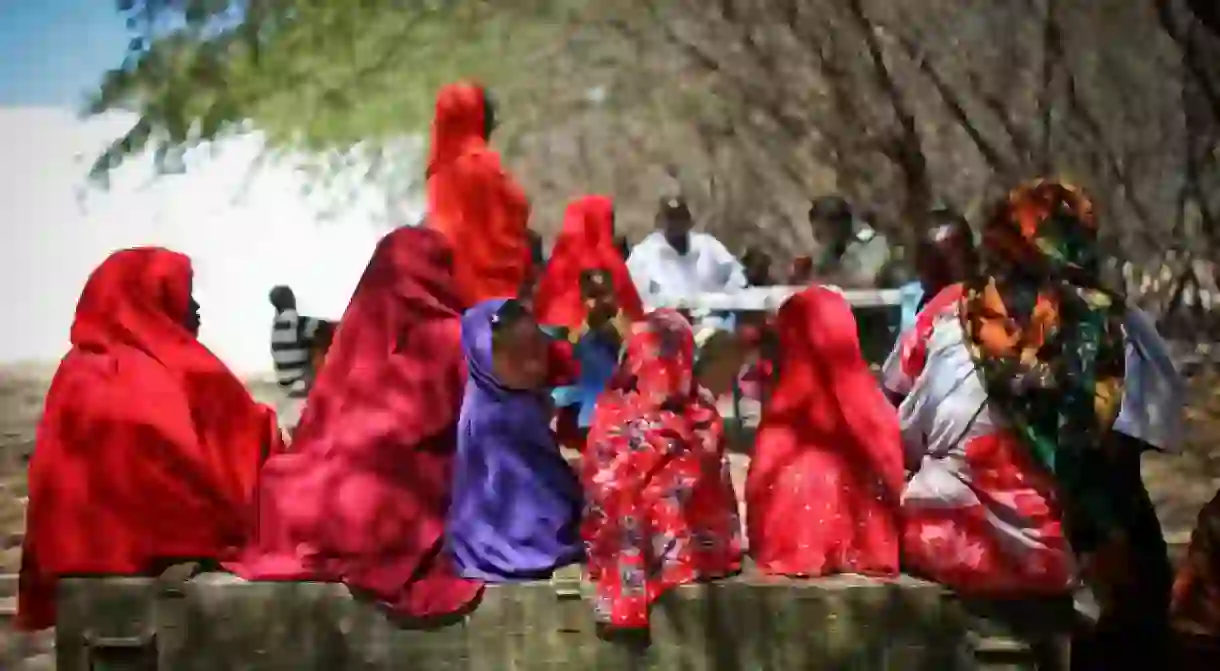 Women and girls from Burundi sitting in the shade