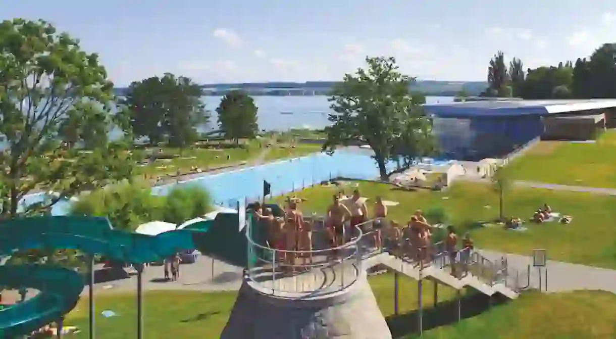 Families getting ready to slide down into the pool on a summer day