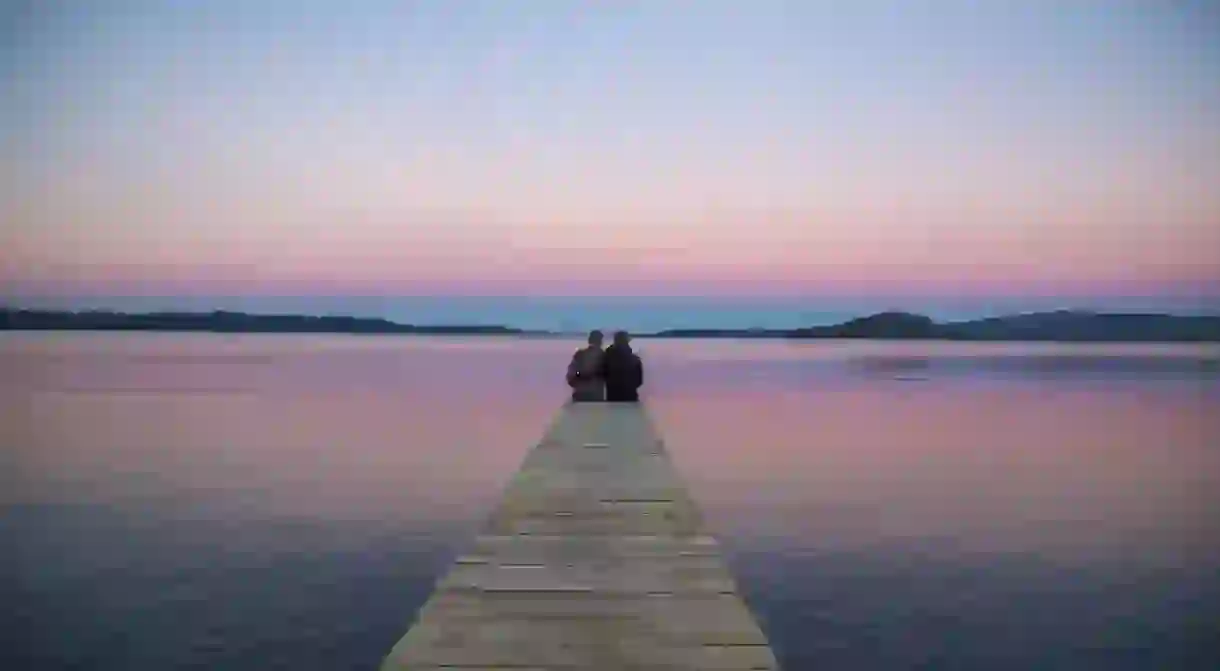 A couple watches the sunset at Lake Rotorua