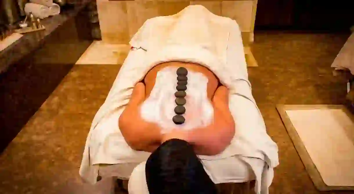 A woman relaxes with a hot stone massage.