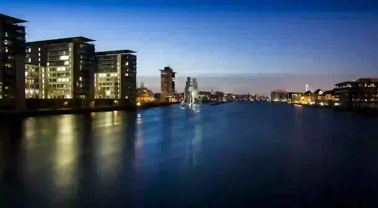 A view of Berlins Skyline at night and Molecule Man in the Spree