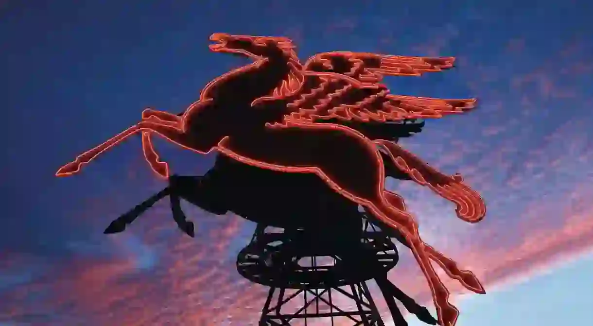 The neon red Pegasus shines bright in front of the Omni Dallas Hotel