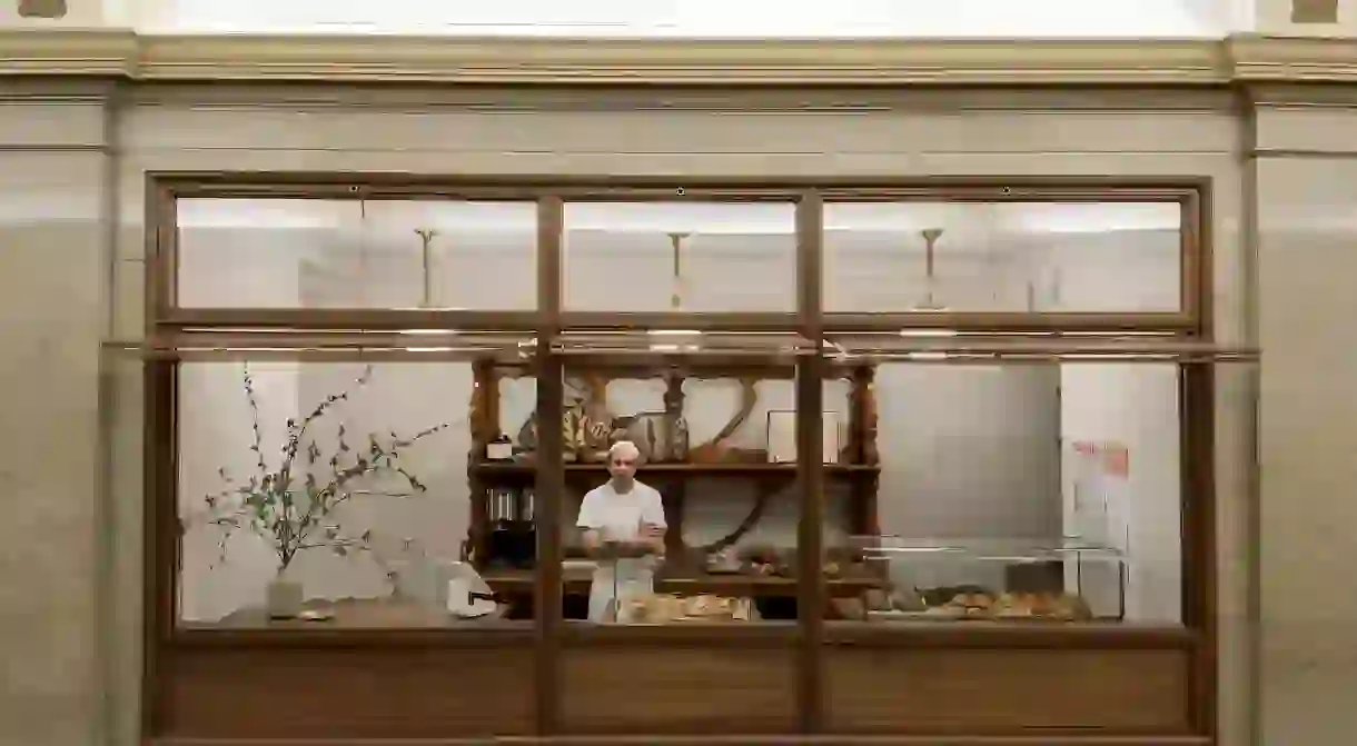 Roger Gural, founder and baker, stands among his many breads and pastries at Arcade Bakery