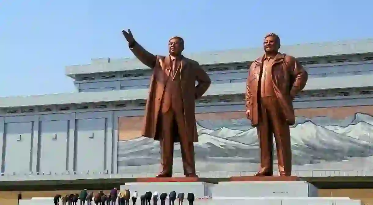 Visitors bowing in a show of respect for North Korean leaders Kim Il-sung and Kim Jong-il