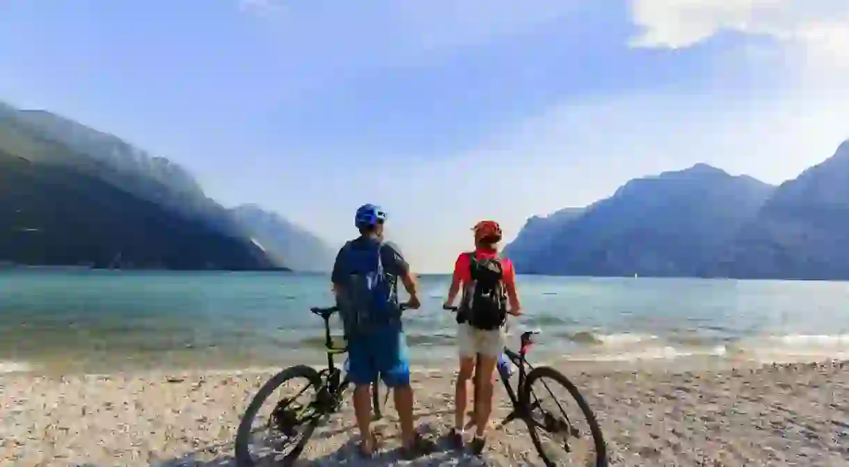 Cyclists take a break on a beach in Lake Garda