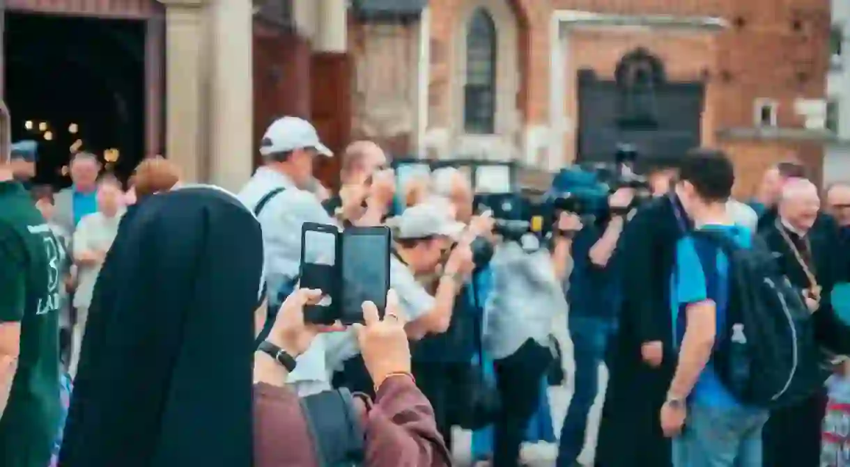 A nun filming on a mobile phone