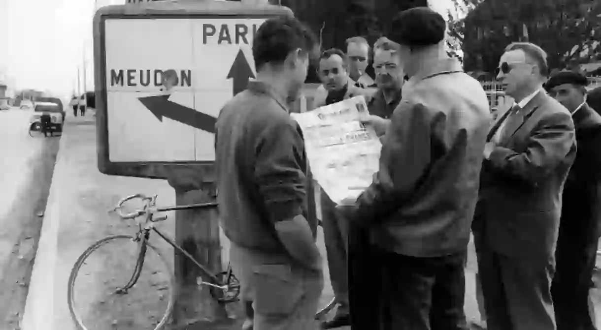 Locals read the newspaper about the assassination attempt on Charles de Gaulle in 1962