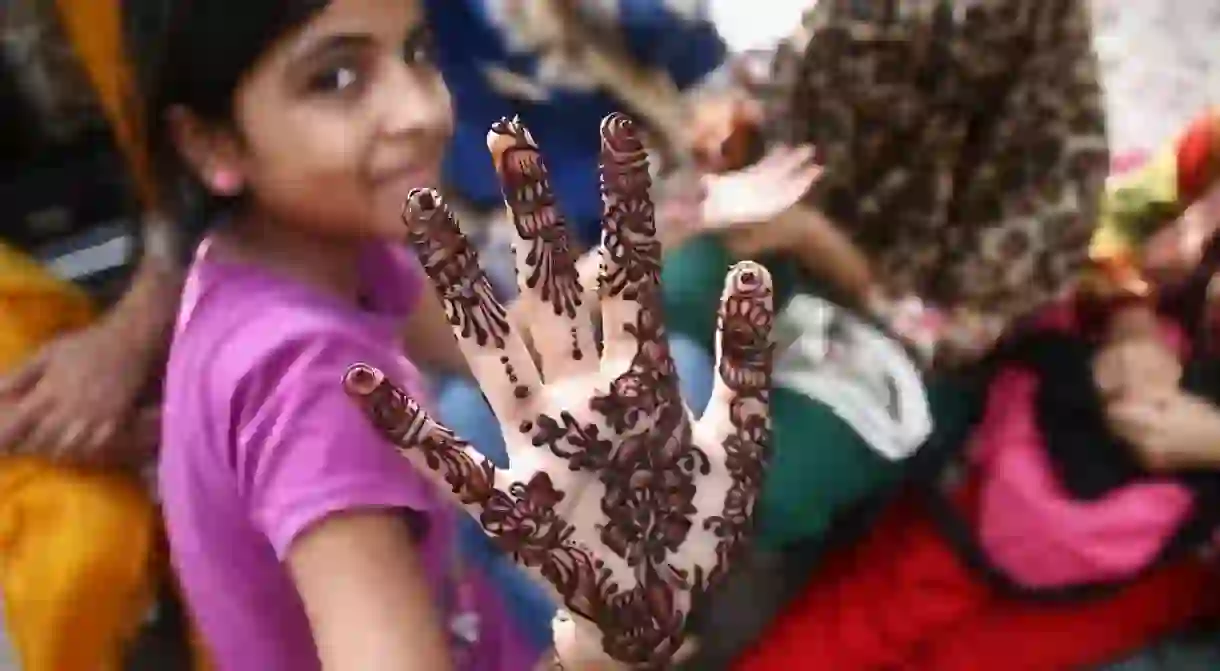 A Pakistani girl shows the henna tattoo on her hand, ahead of Eid al-Fitr