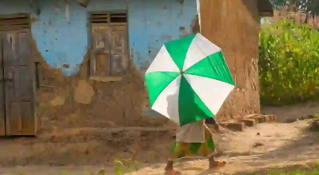 Villager with an umbrella, near Mweya, Uganda