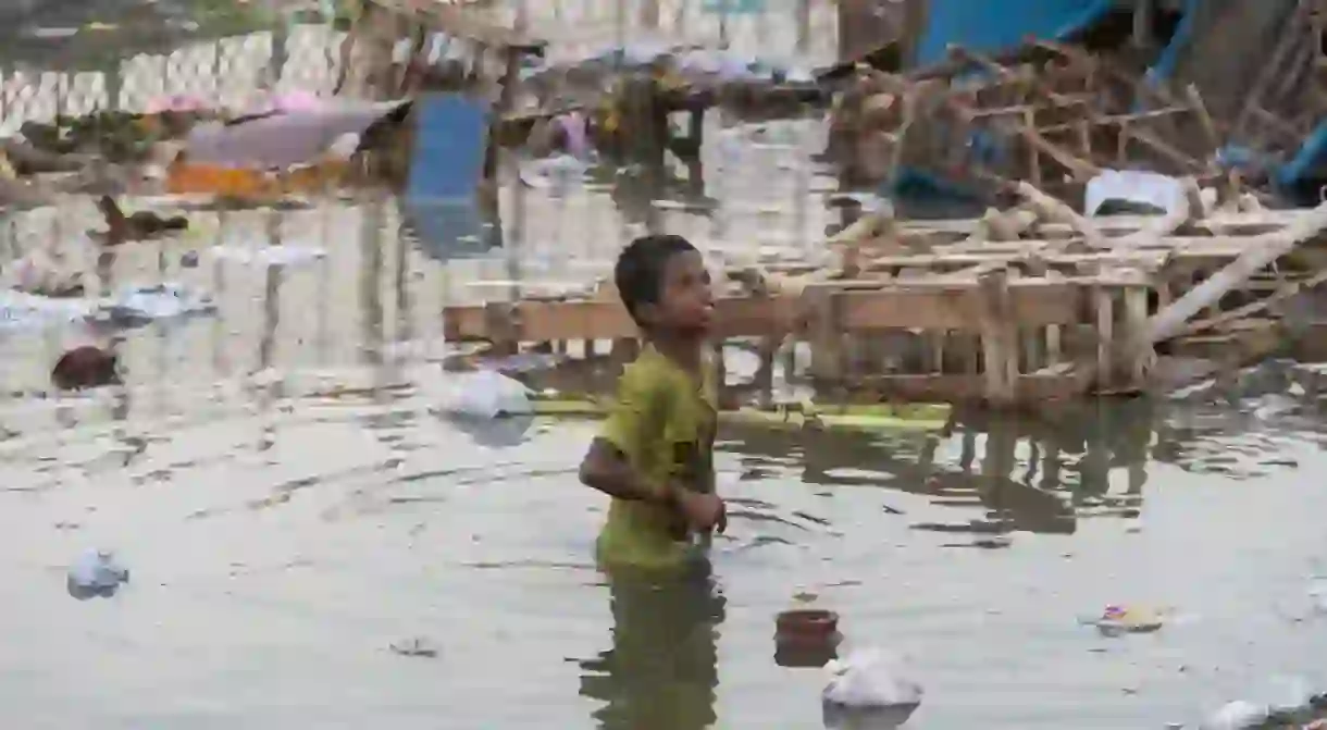 A young boy wading through heavily polluted river waters during the festival of Durga Puja