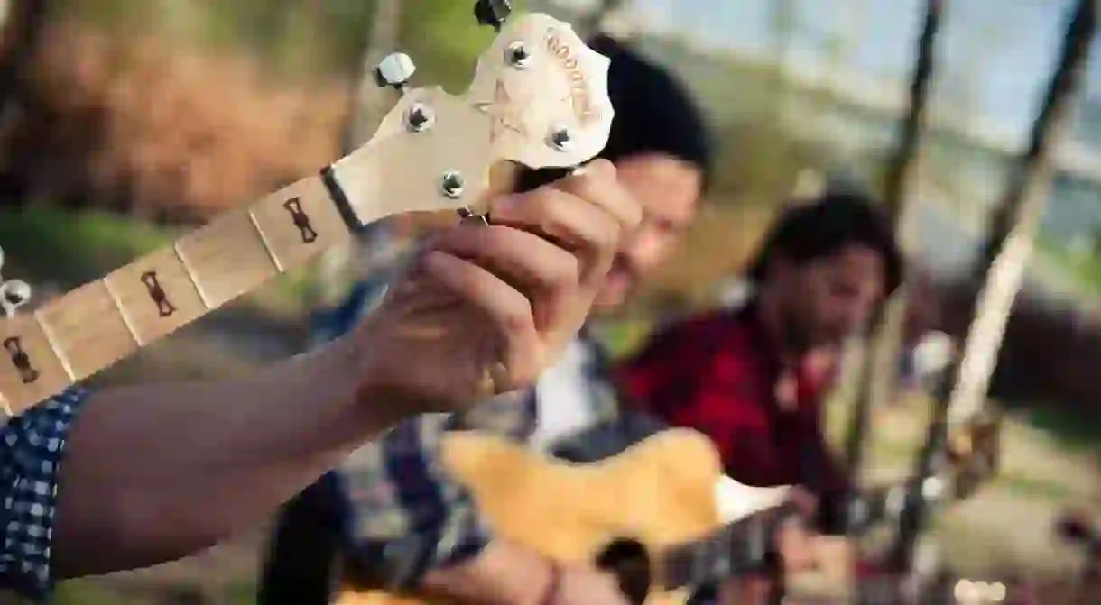 A guitarist tuning his guitar in Mauerpark