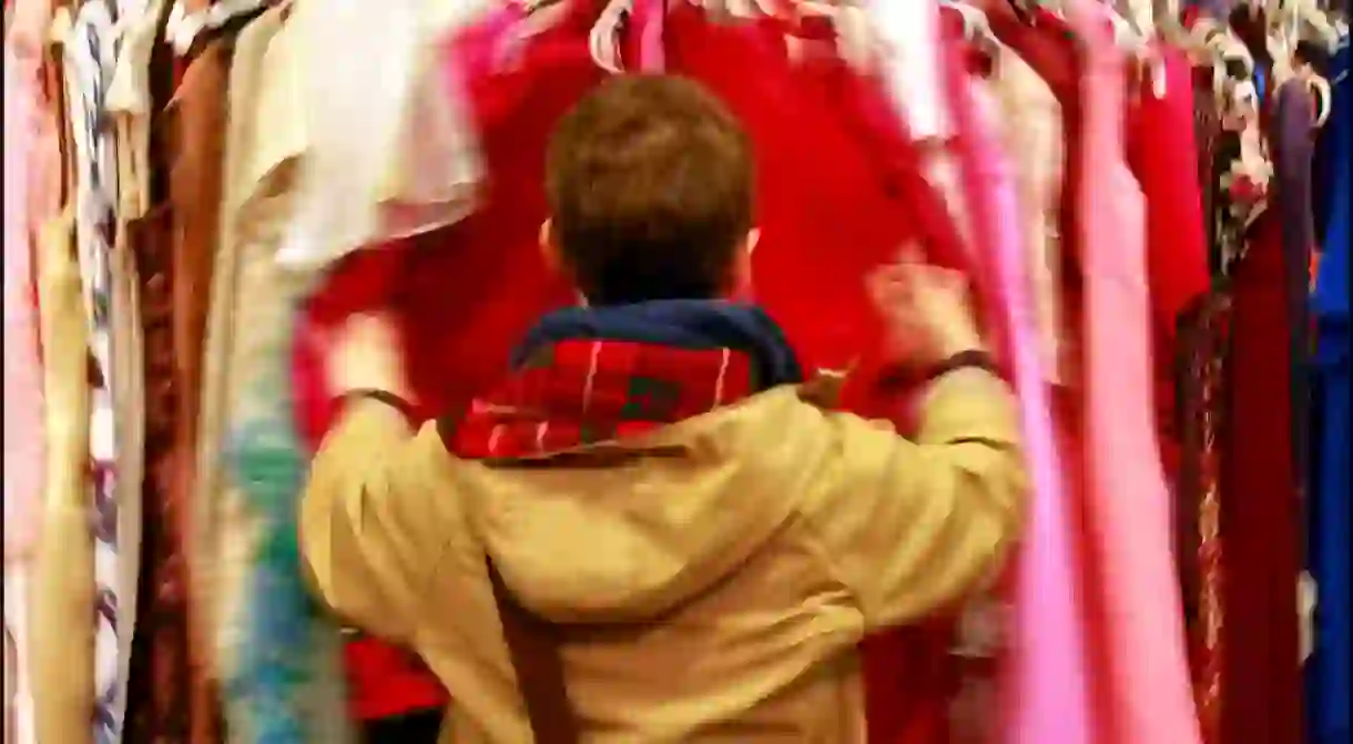 Looking through the colourful clothing racks at a vintage store