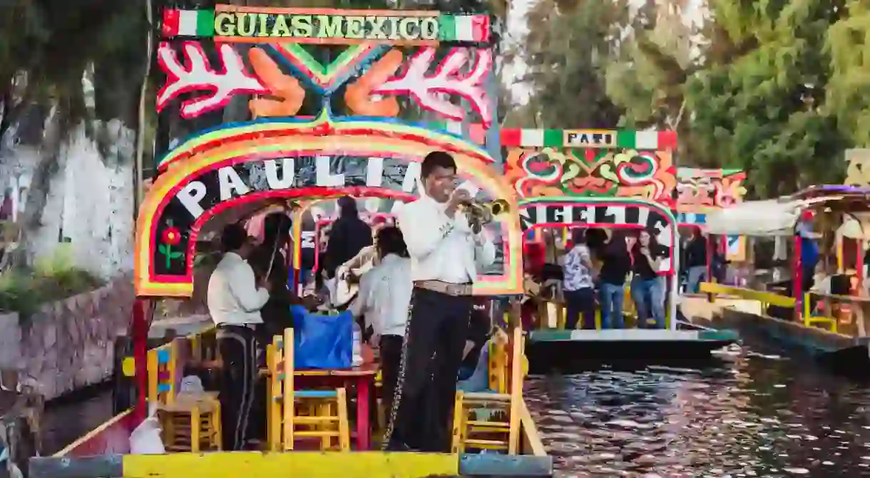 Mariachi bands playing music along the canal