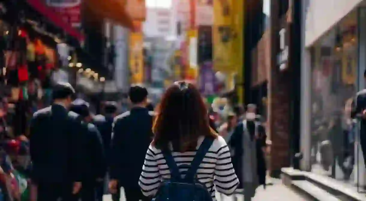 Young woman traveling and shopping in Myeongdong street market at Seoul, South Korea.