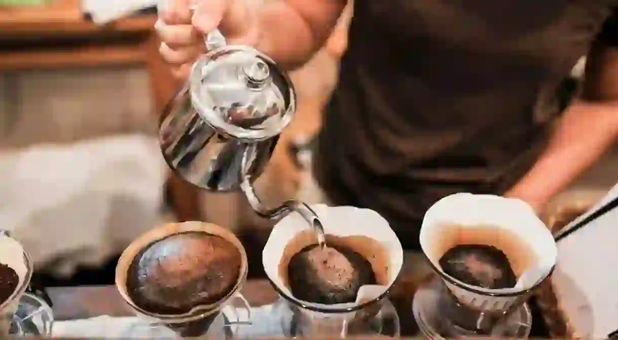 Man using drip brewing, filtered coffee.