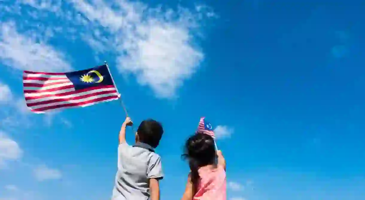 Kids wave a Malaysian flag on Independence day