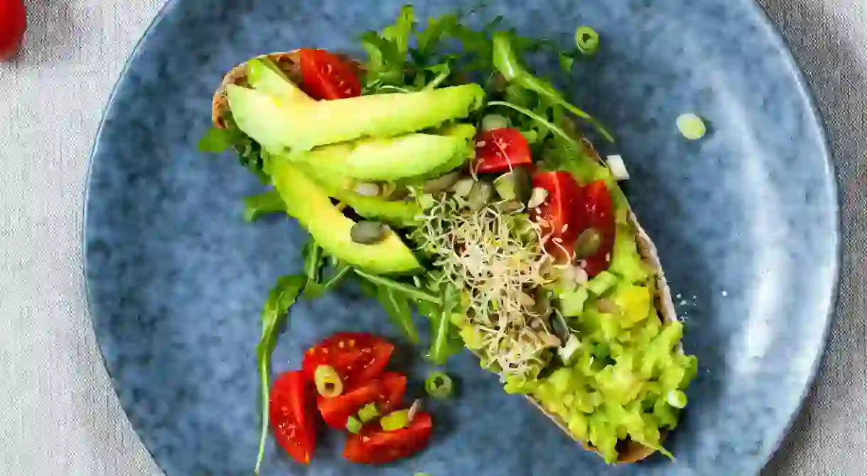 Rye toast with avocado, tomatoes and alfalfa sprouts