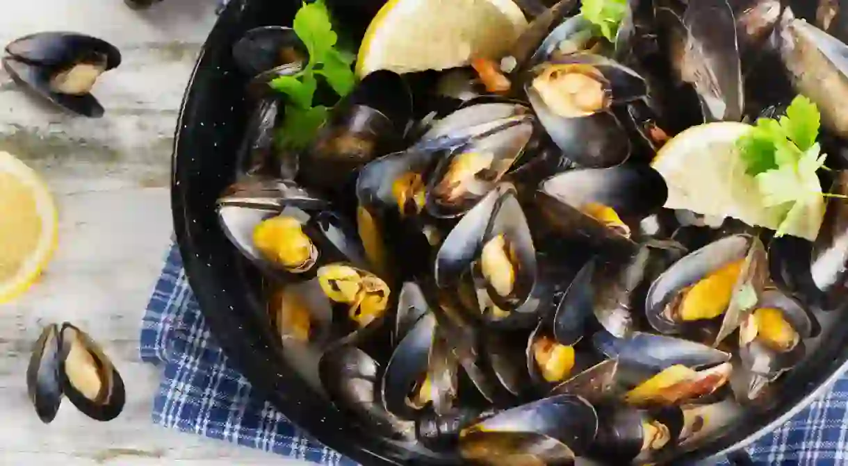 Gourmet mussels served on a napkin garnished with lemon slices