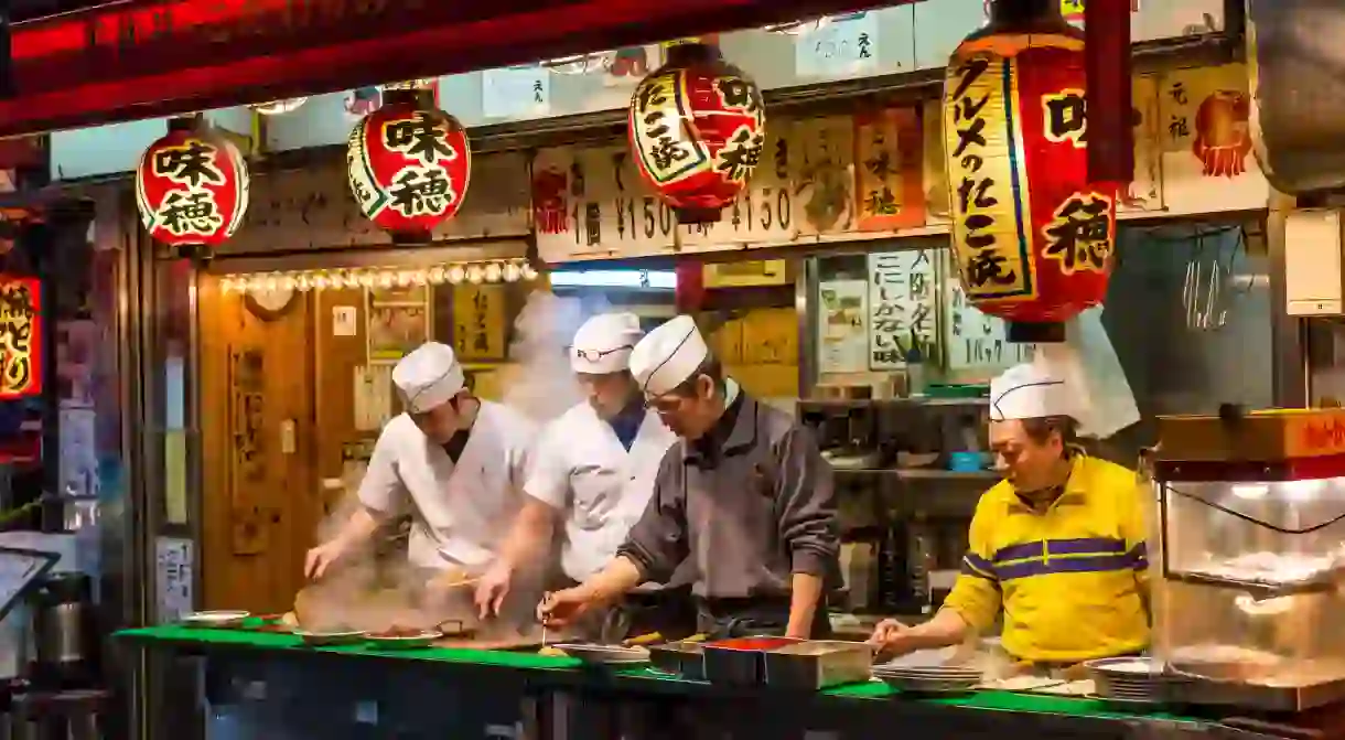 Japanese chefs prepare snack foods at a stall in Osaka, Japan.