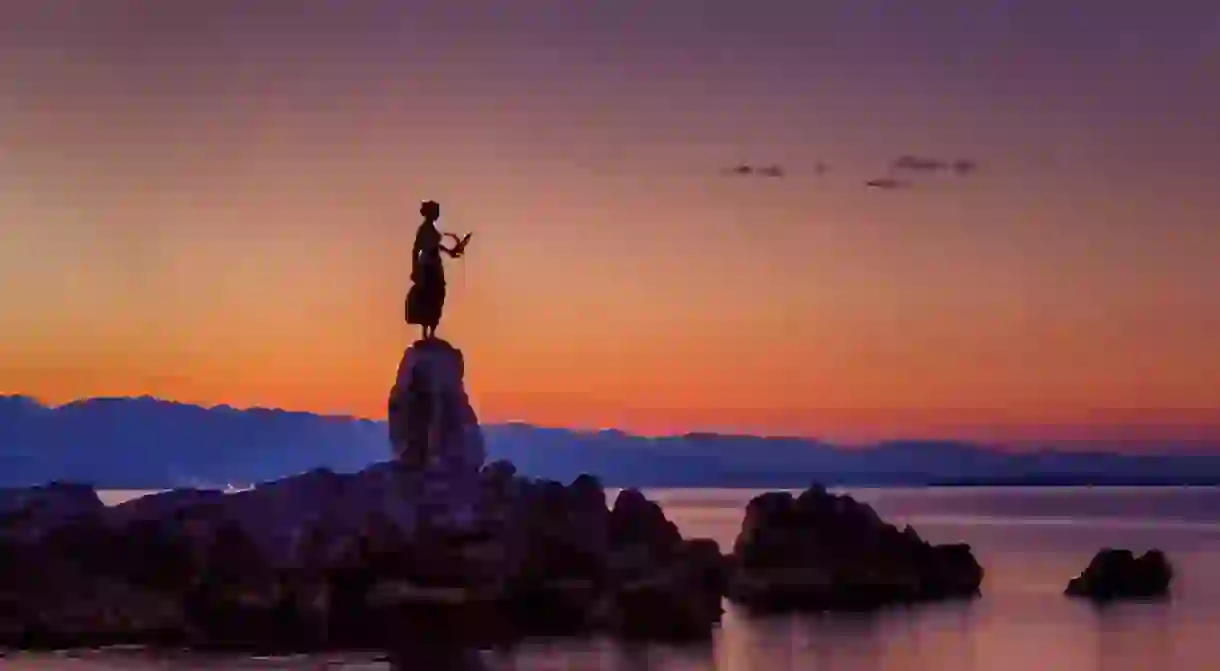 Statue of a girl holding a seagull in Opatija, Croatia.