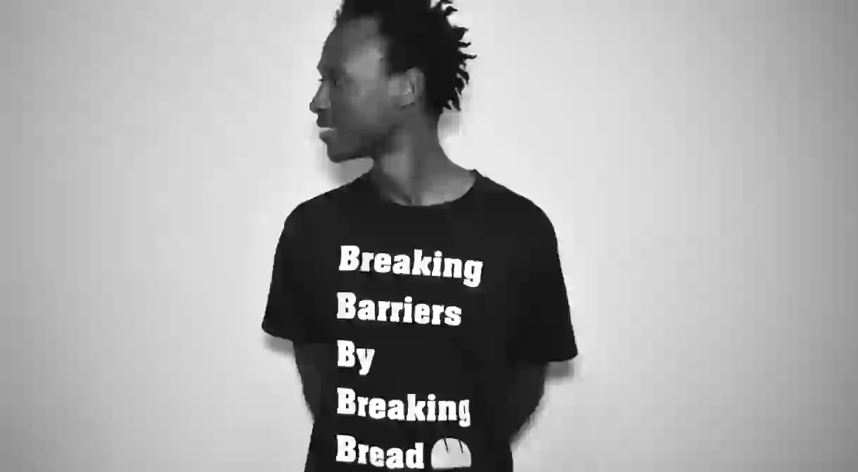 Immigrant Food Fest Co-Founder Daniel Bright shows off the festivals motto: Breaking Barriers by Breaking Bread