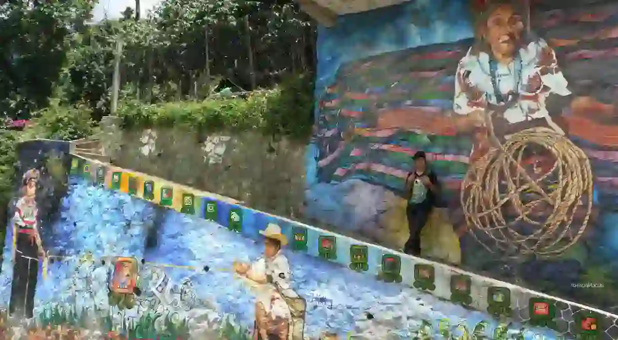 Miguel Ujpán in front of his mural in San Pablo la Laguna, Guatemala