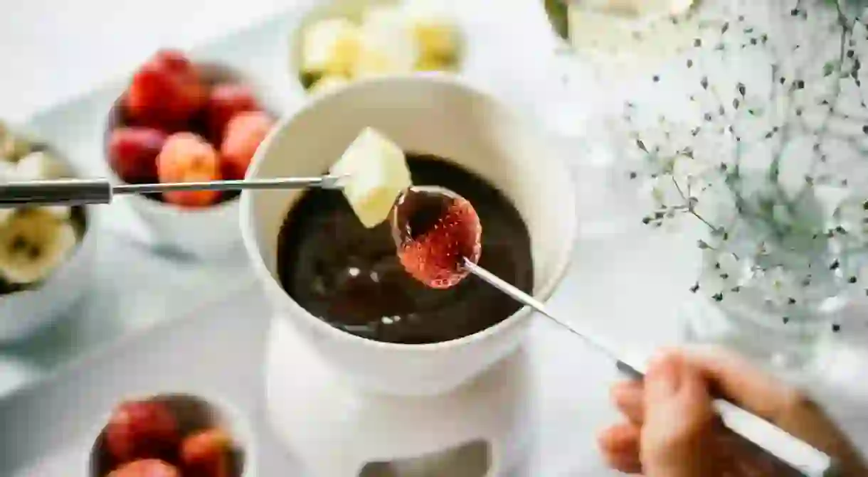 Chocolate fondue served with fruits.