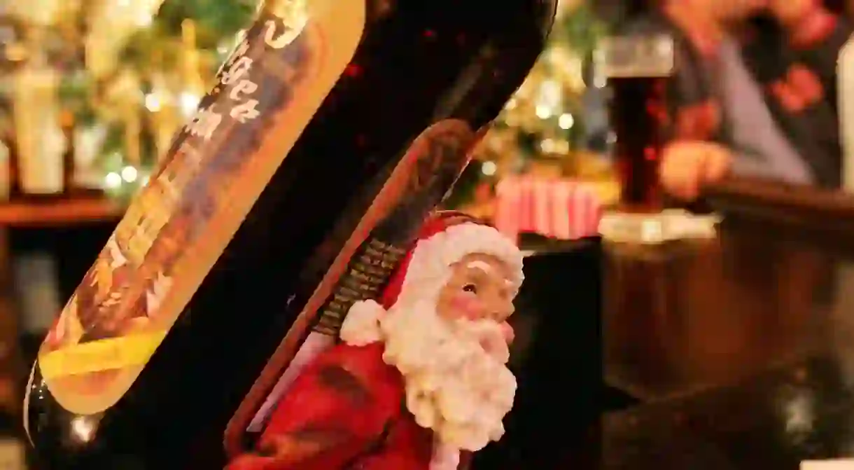 NEA decorative Santa bottle holder lies on a counter as patrons enjoy the traditional Christmas wunderland decor in Rolfs German restaurant in New York City. The 19th-century German tavern decorates for the Christmas season with artificial fir trees and pine garlands, Victorian dolls and thousands of Christmas lights.