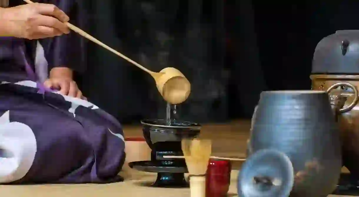 A woman demonstrates a Japanese tea ceremony