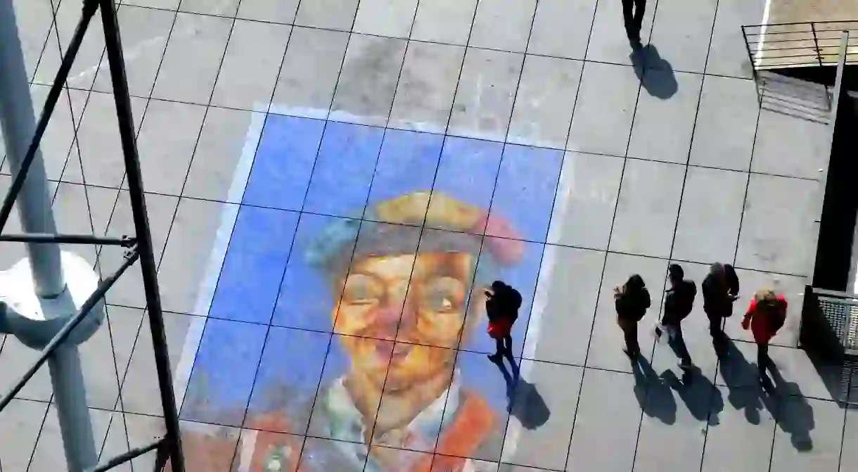 A group of people admire a piece of street art in front of the Centre Pompidou in Paris