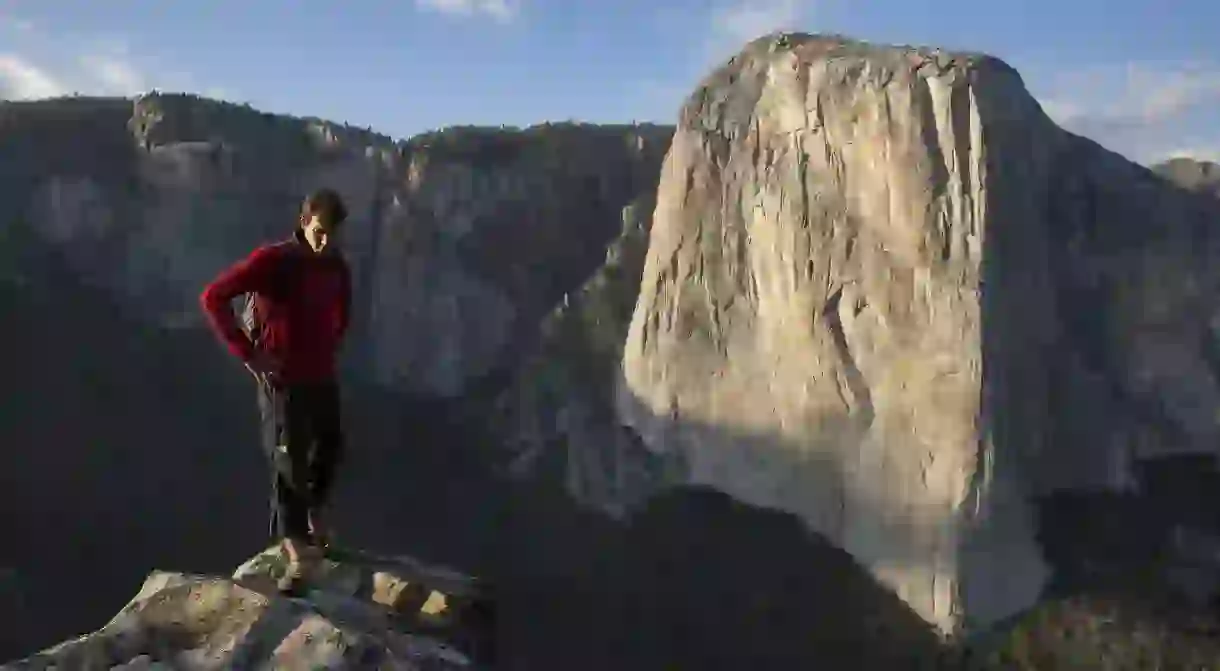 Alex Honnold stands with El Capitan in the background