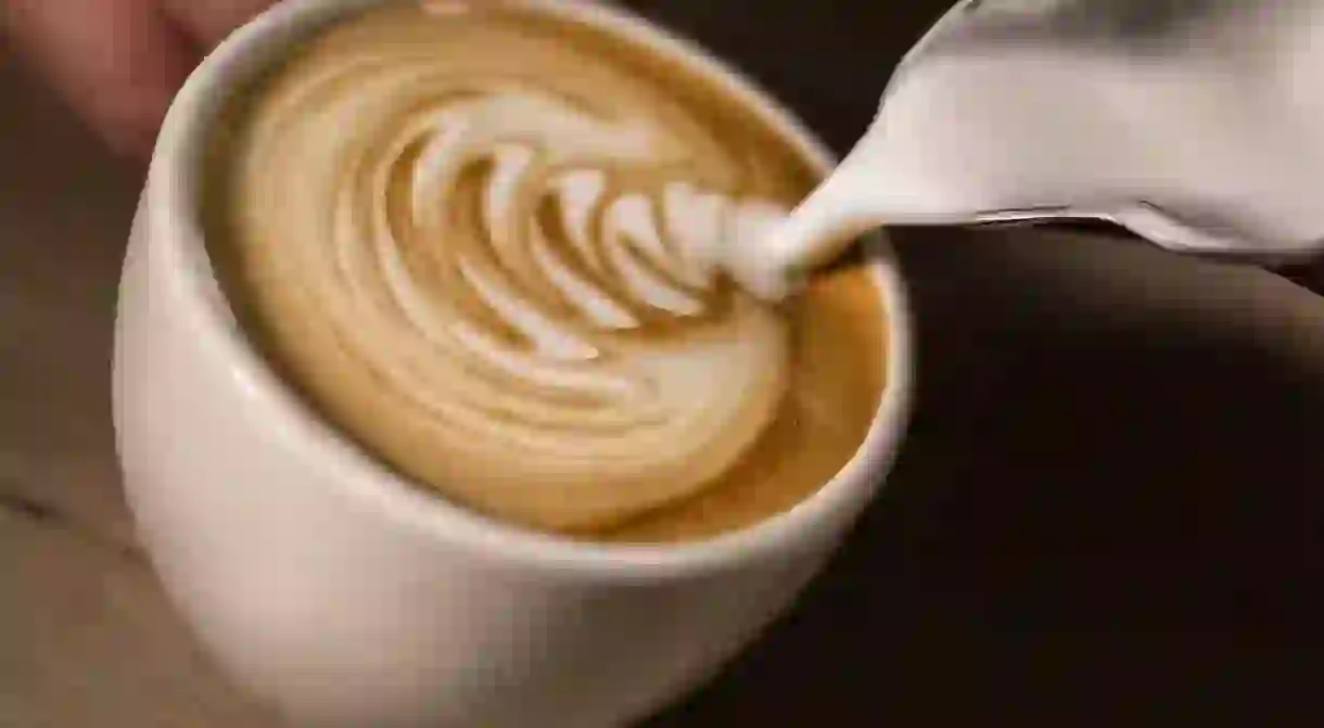 A barista prepares a latte