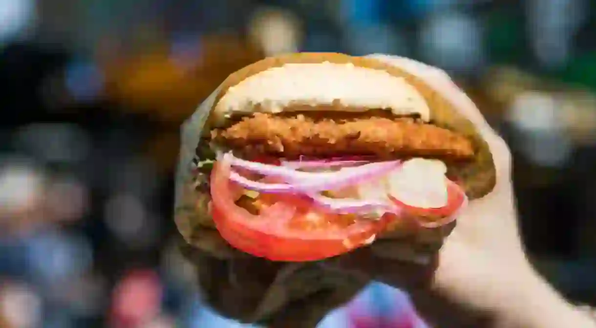 Vegan deep fried Seitan burger with tomatoes and onions