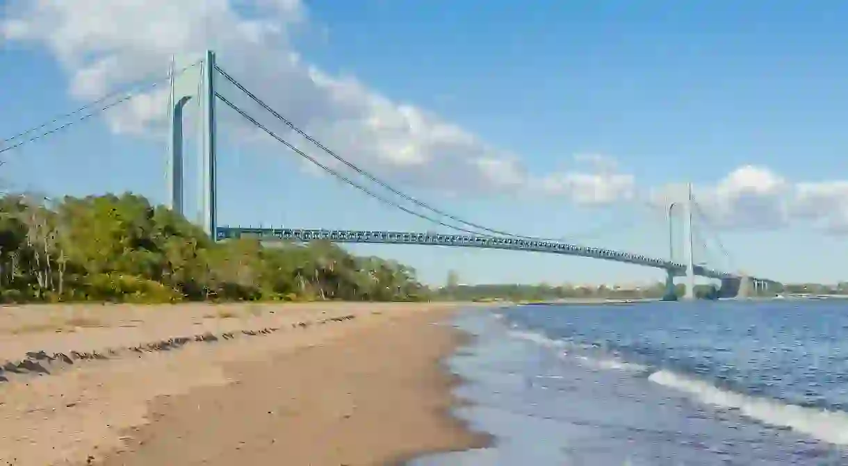 The Verrazzano-Narrows Bridge rises behind Staten Island Beach