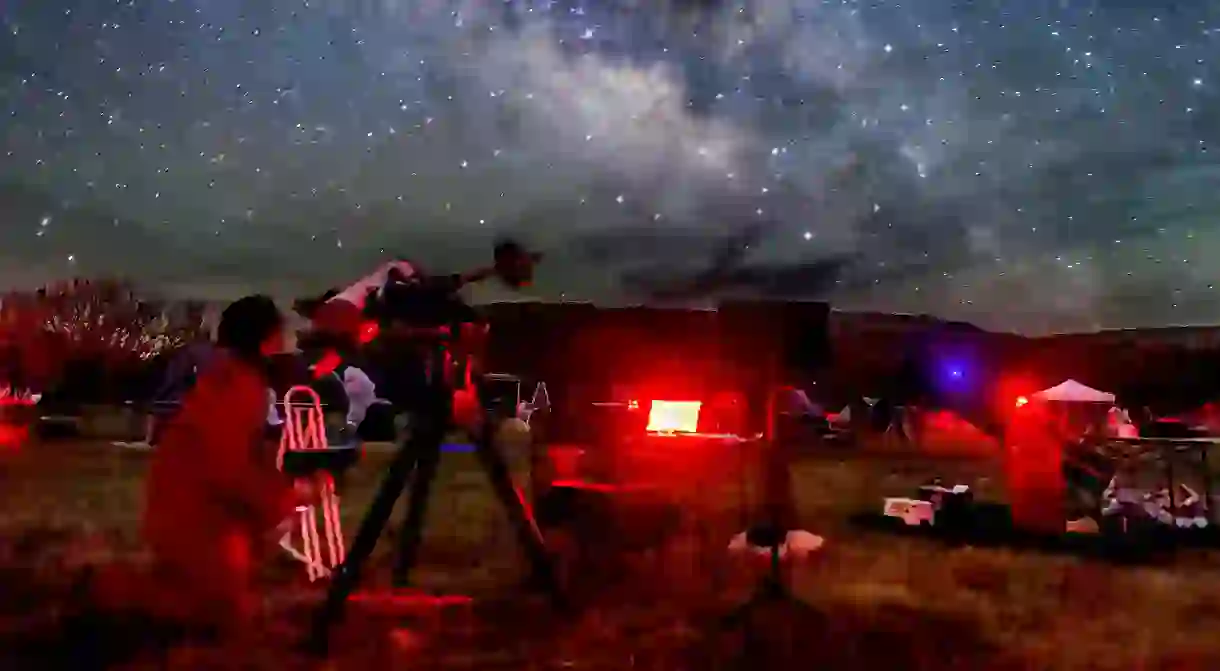 An observer at the Texas Star Party aims his telescope at a target in the Milky Way