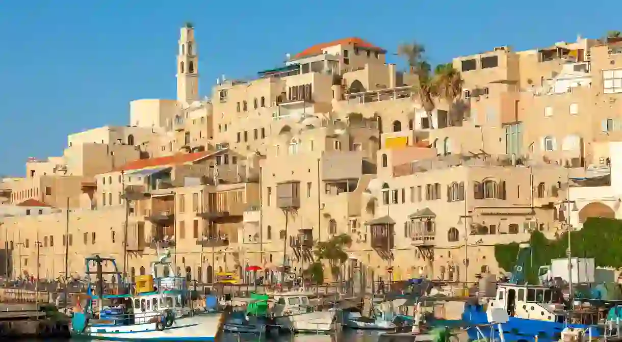 Boats crowd a harbour in Jaffa under an empty sky