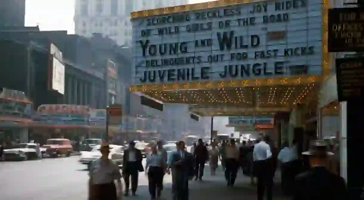 People pass by a theater showing ‘Young and Wild’ in New York in 1958