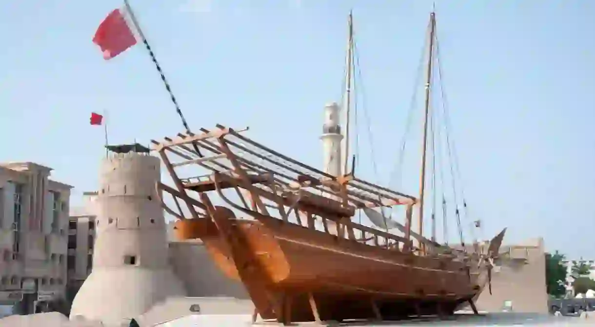 The Dubai Museum features a traditional wooden dhow outside