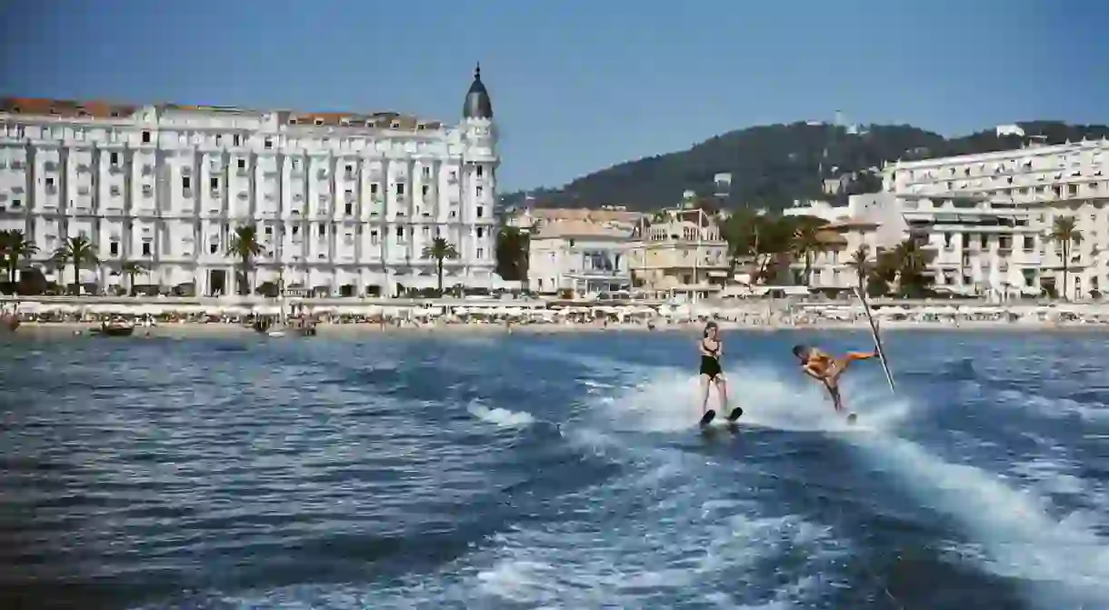 Holidaymakers waterski in front of the Carlton Hotel, Cannes, 1958