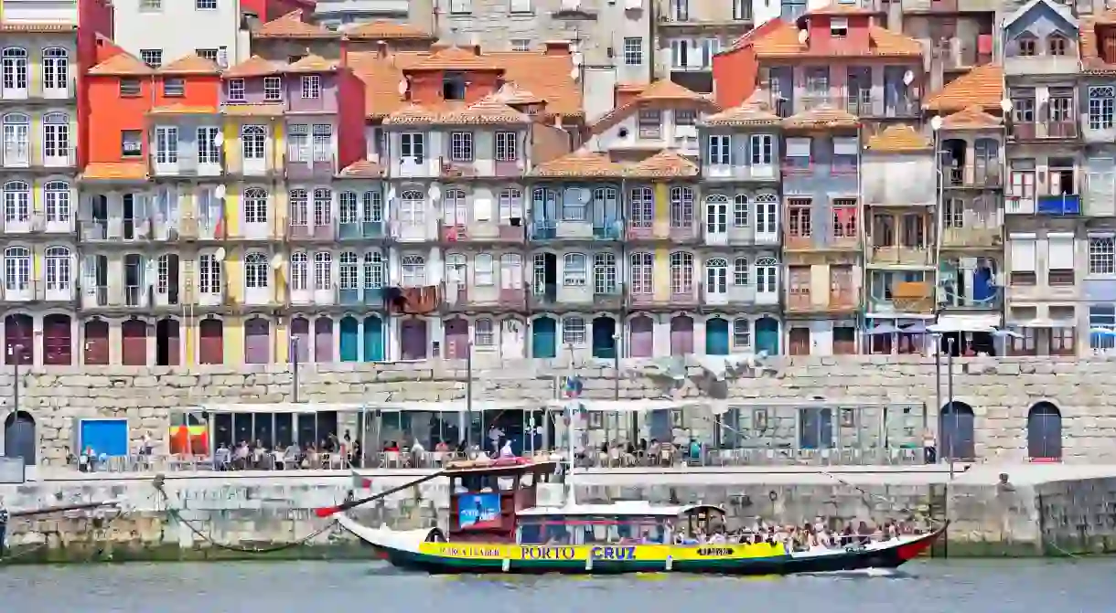 A boat passes alongside Portos famous riverfront in the old town