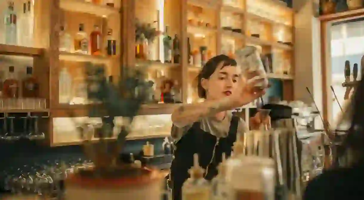 Bartender pouring cocktails behind a bar counter