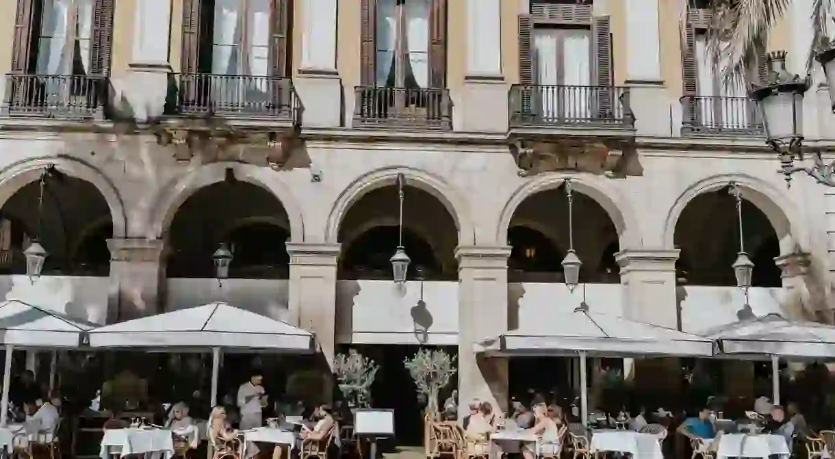 People having tapas and beers at Plaça Reial, El Gotico, Barcelona, Spain, 2019.