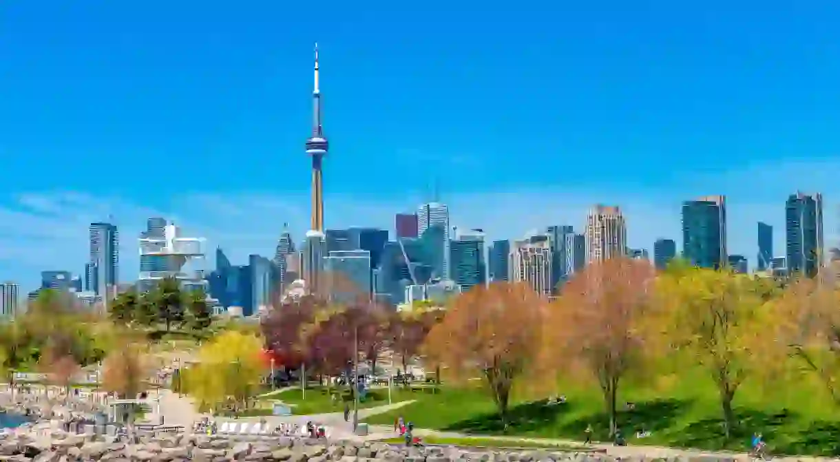 The CN Tower juts into a typically blue sky above Toronto