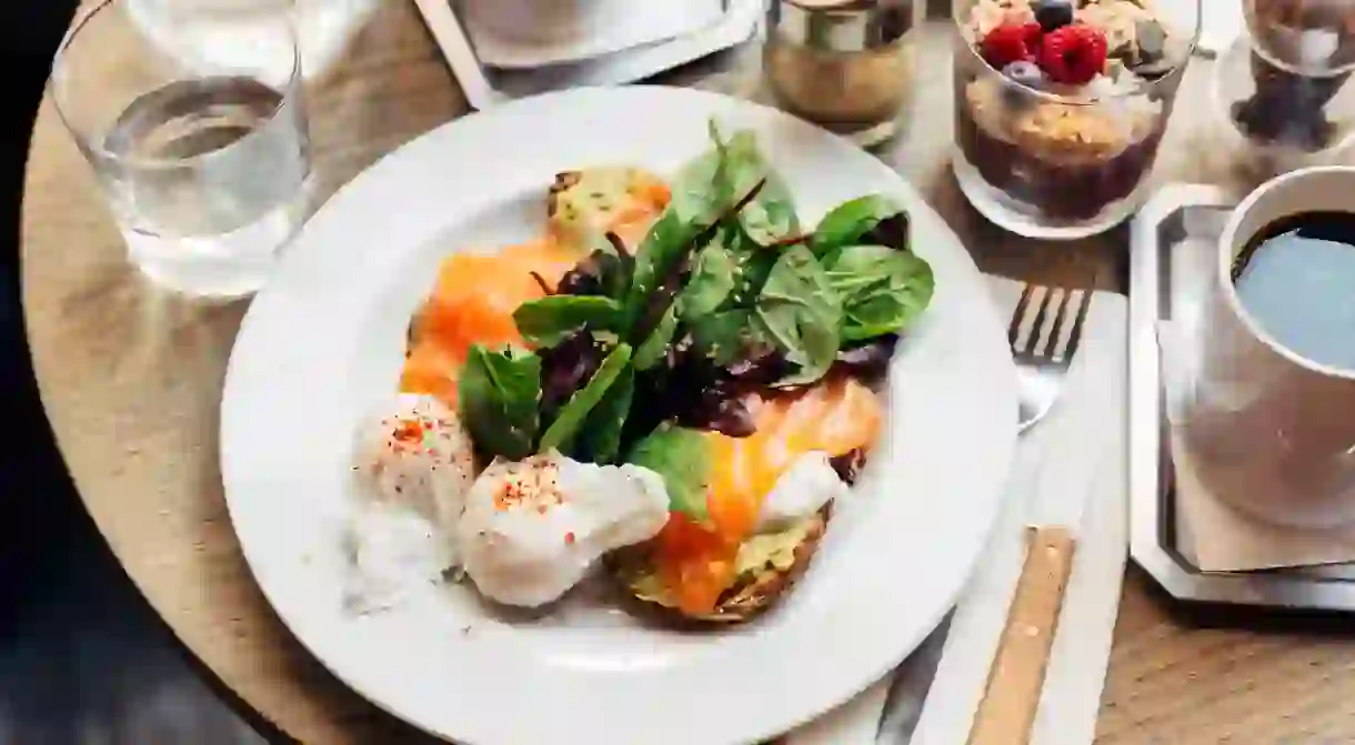 Breakfast with avocado on toast, poached egg and spinach