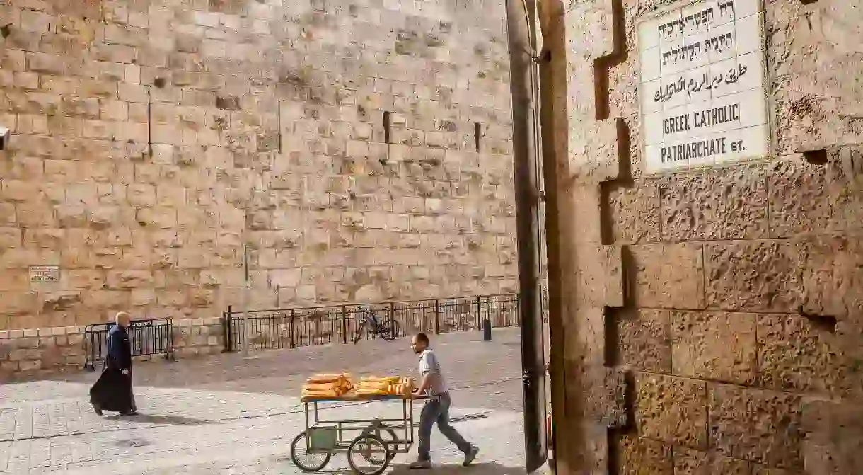 A bread vendor walks down Greek Catholic Patriarchate Street, near Jaffa Gate in the Old City, Jerusalem