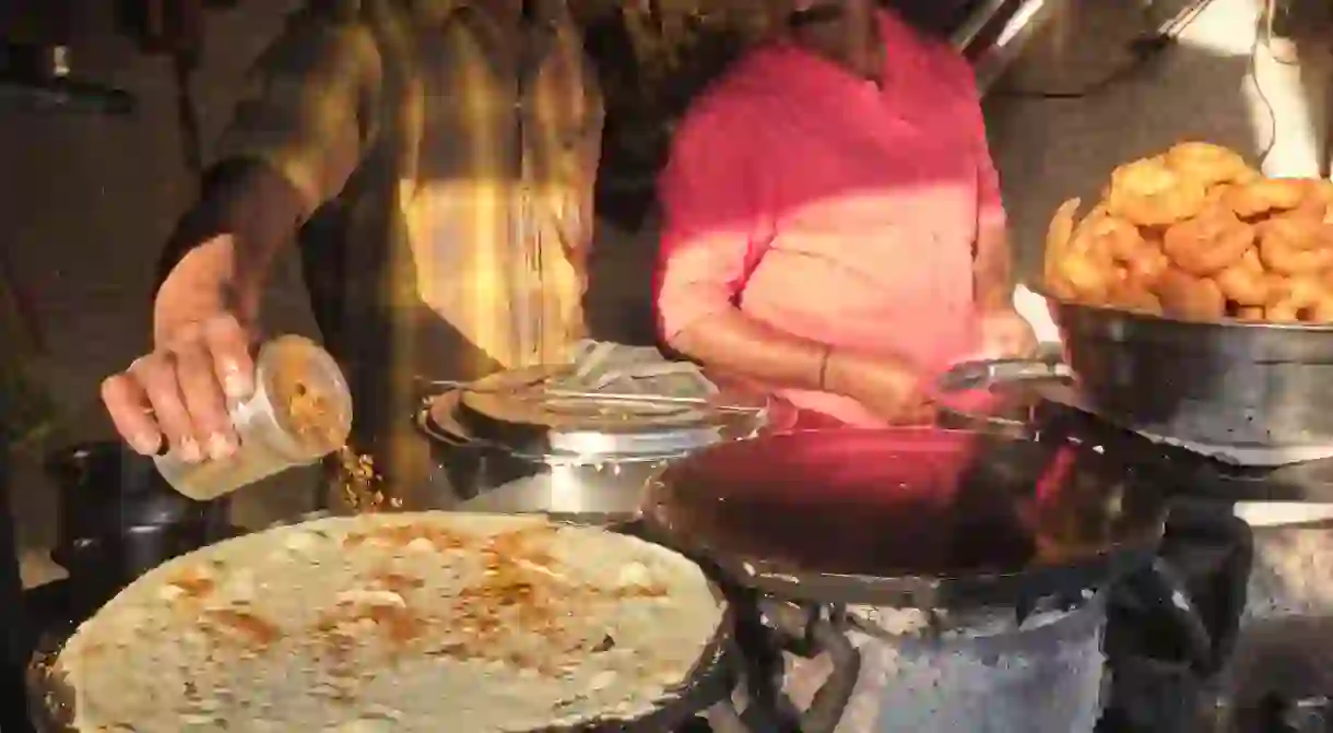 At a food stall in Mumbai, a cook makes Dosa