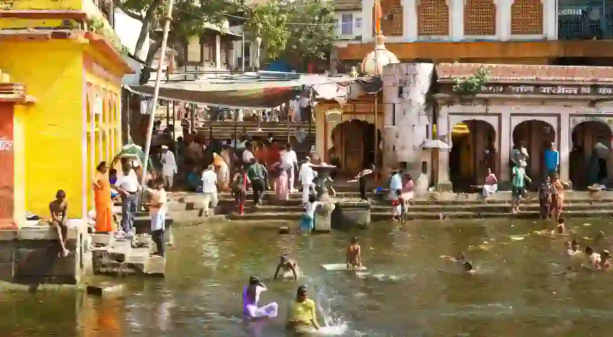 People bathe in the holy water of the Godavari River at Ram Kund