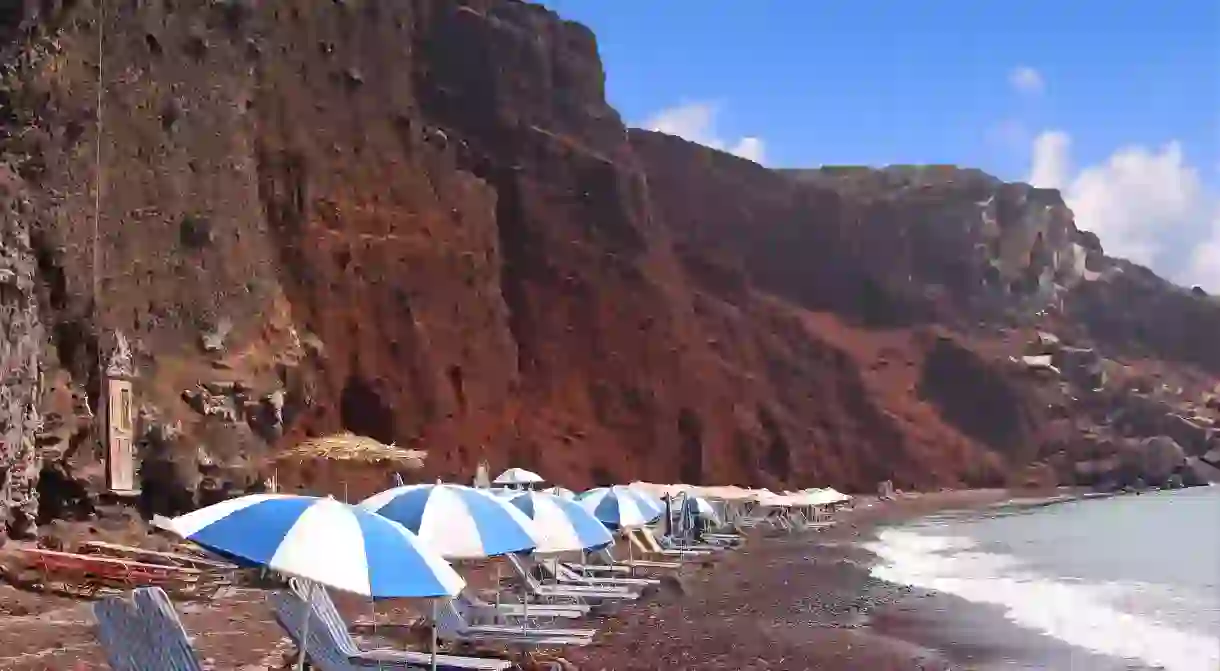 The backdrop of red volcanic rocks is a big draw to the Red Beach on Santorini