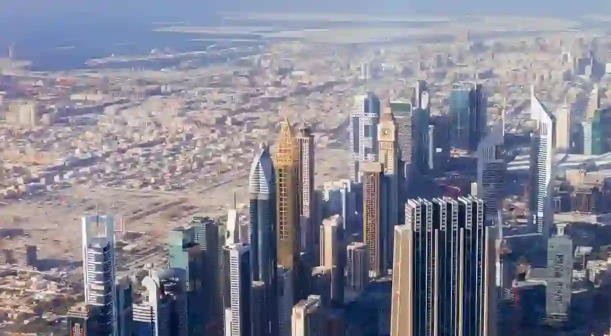 Dubais spectacular skyline from above shows the contrast of the old desert city in the distance and the high-rise modernity of today